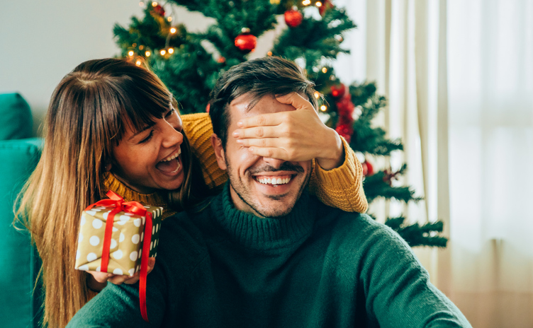 Romantic young couple exchanging Christmas gifts