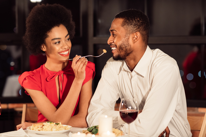 Loving Afro Couple Having Date Feeding Each Other In Restaurant